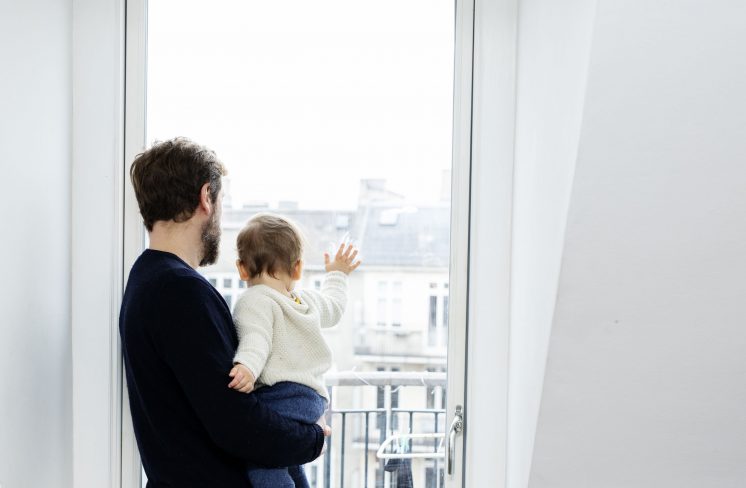 Far og barn kigger ud af vinduet. Foto: Rie Neuchs