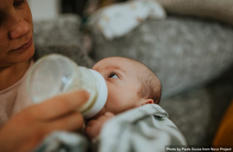 Nyfødt baby får mælk fra flaske.