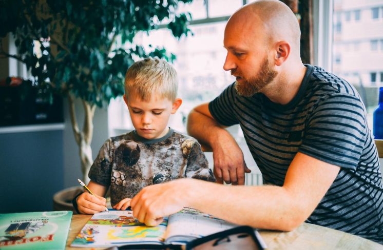 Dreng læser lektier med far